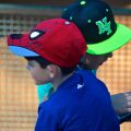 Two boys in baseball caps outside