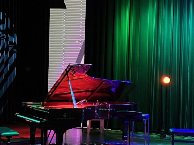 A grand piano on a colorful stage