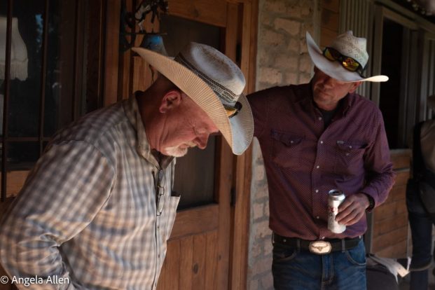 Two cowboys commiserating over a beer